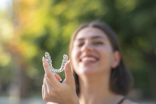 Piękna uśmiechnięta Turczynka trzyma aparat invisalign