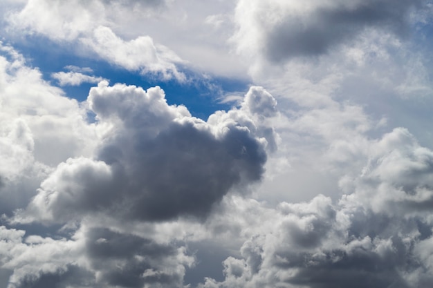 Piękne białe i szare chmury cumulus na niebieskim niebie.