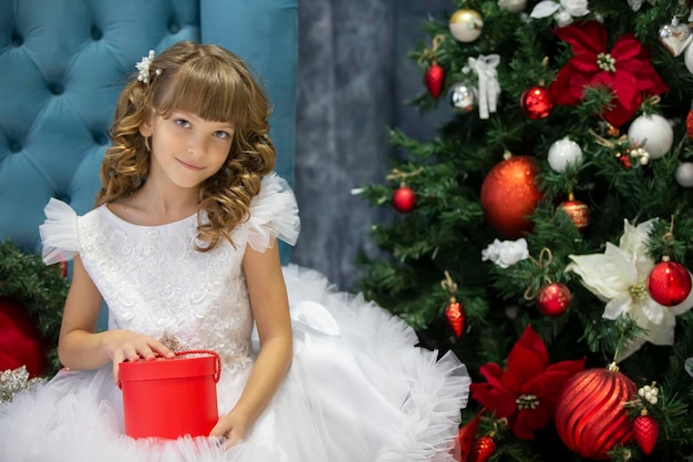 Piękne dziecko z prezentem świątecznym Ubieranie dziewczyny na drzewie Nowego Roku