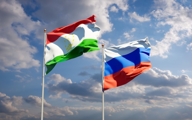 Piękne flagi państwowe Tadżykistanu i Rosji razem na błękitne niebo. Grafika 3D