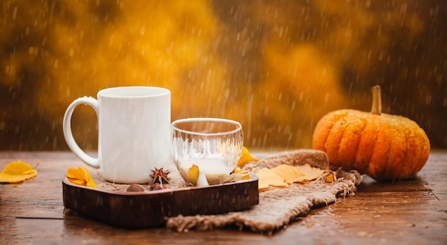 Zdjęcie piękne kieliszki herbaty lub rumianku na stole w deszczu