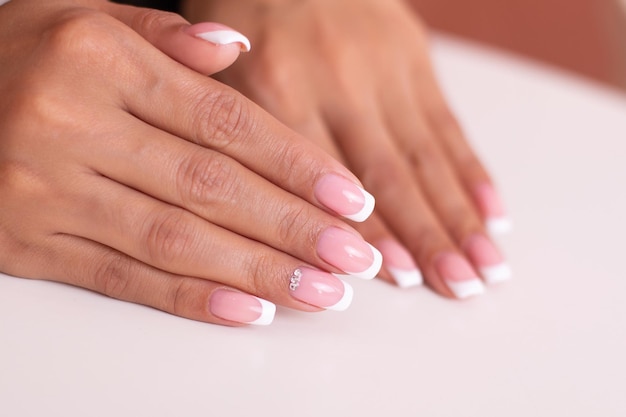 Piękne kobiece dłonie z francuskim manicure