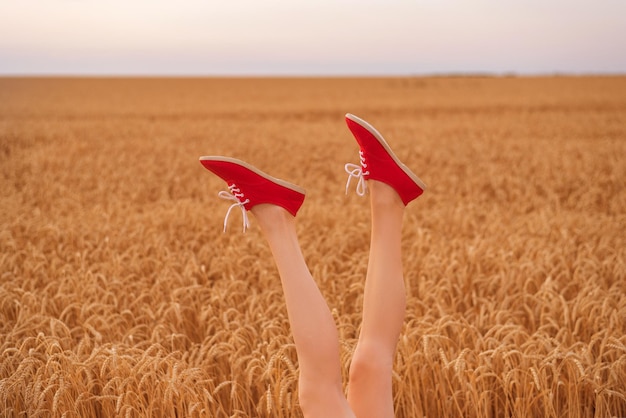 Piękne kobiece nogi wystające z pola dojrzałej pszenicy Bądź sobą koncepcja
