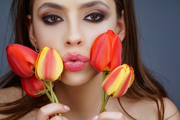 Piękne kobiety, które dobrze się czują, odpoczywają z kwiatami tulipanów.