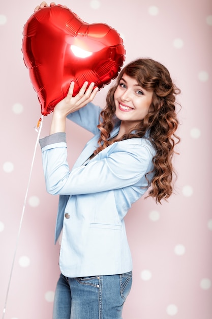 Piękne kręcone kobiety z balonami w kształcie serca na Walentynki