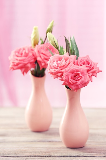Zdjęcie piękne kwiaty w wazonach na stole na tle zasłon