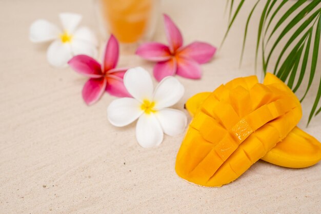 Piękne Mango Pokrojone Na Piaszczystej Plaży Obok Liści Palmowych I Kwiatów Frangipani