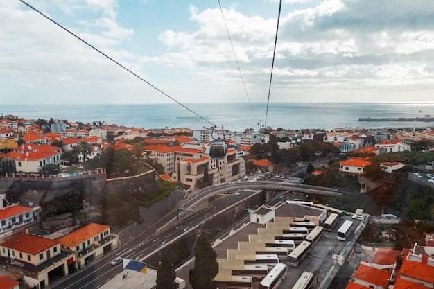 Piękne miasto Funchal z domami pomarańczowymi dachami i kolejkami linowymi na wyspie Madera w pobliżu oceanu