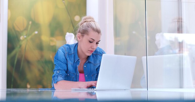 piękne młode kobiety korzystające z laptopa na podłodze swojego luksusowego domu
