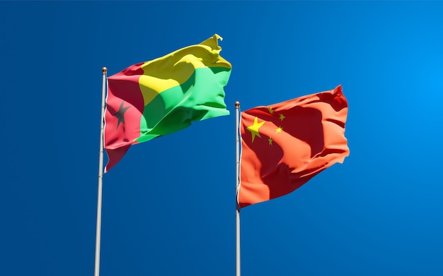 Piękne narodowe flagi państwowe Chin i Gwinei Bissau razem na niebie