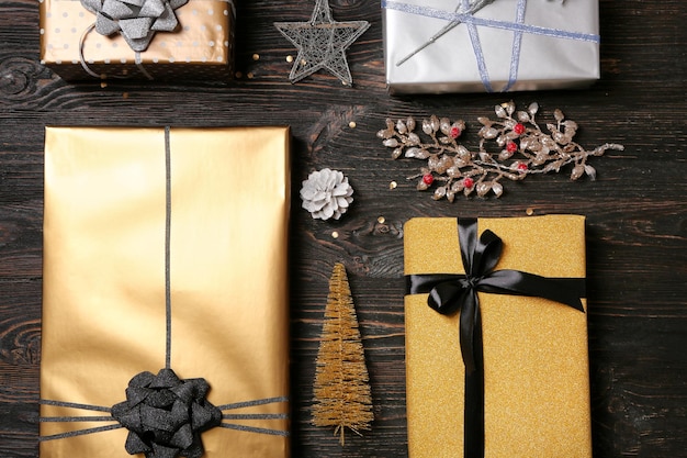 Piękne pudełka na prezenty i świąteczne dekoracje na drewnianym tle, płaskie lay