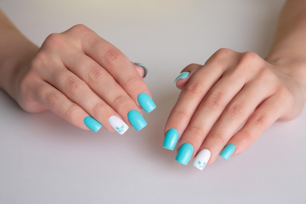 Piękne ręce kobiece z romantycznym manicure paznokcie niebieski i biały lakier żelowy