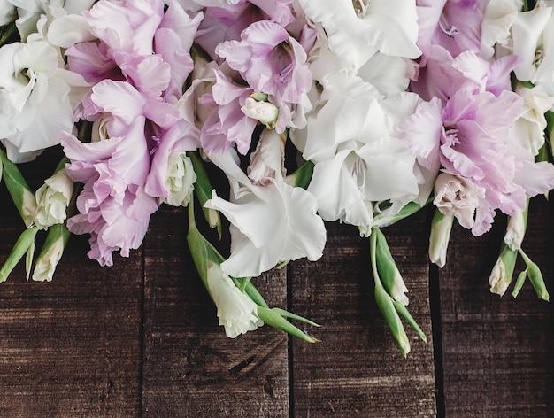 Piękne różowe i białe mieczyki na rustykalnym drewnianym tle płaskie leżały kolorowe mieczyki na rustykalnym brązowym drewnie miejsce na tekst wakacje kartkę z życzeniami wiosna obraz dzień matki kobiety