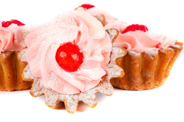 Piękne słodycze Kosz ciastek z różowym kremem ozdobionym czerwonymi jagodami