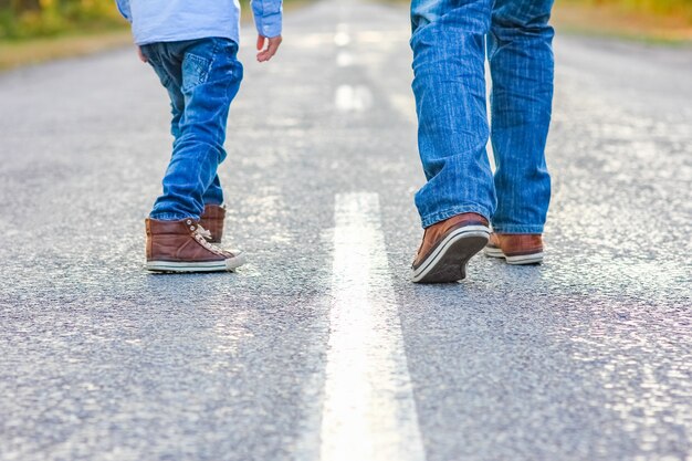 Piękne stopy rodzica i dziecka na drodze w parku na podróż natury