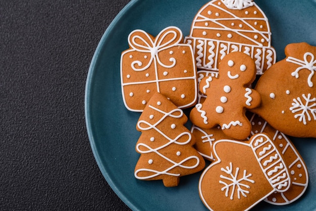 Piękne świąteczne ciasteczka imbirowe o różnych kolorach na ceramicznym talerzu