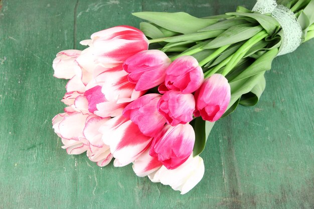 Piękne tulipany na kolorowym drewnianym tle