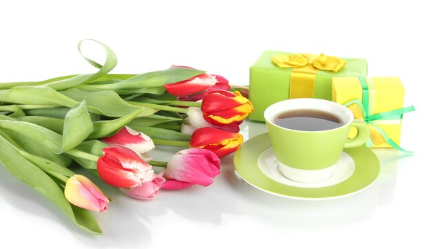 Piękne tulipany w wiadrze z prezentami i filiżanką herbaty na białym tle