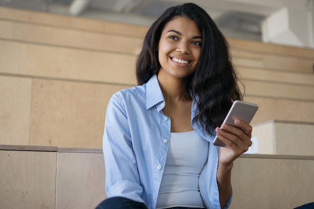 Piękne Uśmiechnięte African American Kobieta Za Pomocą Telefonu Komórkowego