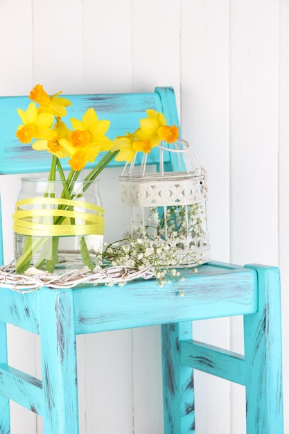 Piękne wiosenne kwiaty na niebieskim starym drewnianym krześle