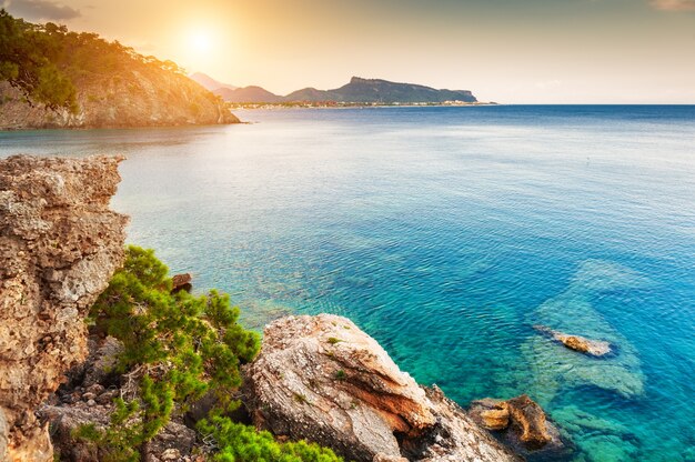 Piękne wybrzeże morskie z turkusową wodą o zachodzie słońca. Kemer, Turcja.