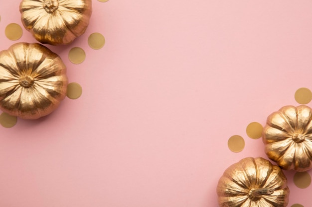 Piękne złote dynie na pastelowo różowej płaskiej kompozycji na Święto Dziękczynienia