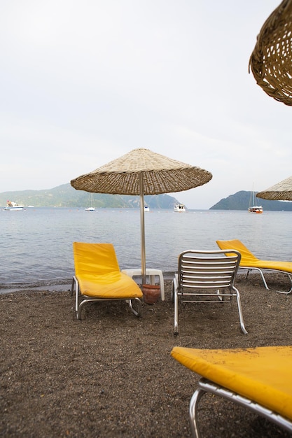 Piękne żółte szezlongi i parasole ze słomy na plaży Marmaris