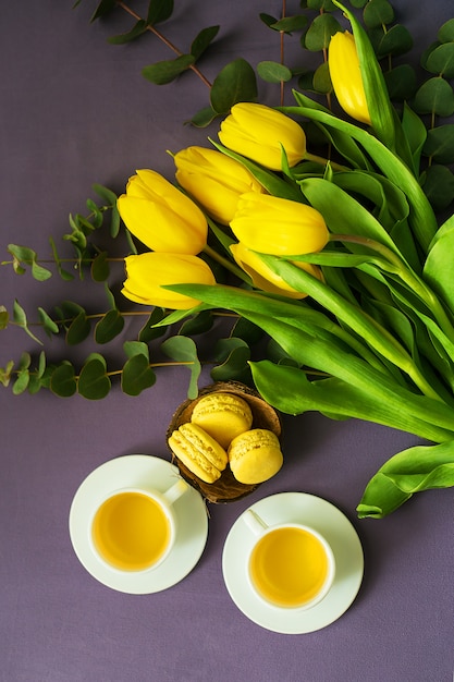 Piękne żółte tulipany z gorącym napojem i macarons