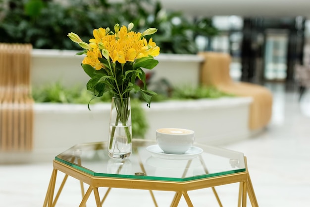 Piękne żółte wiosenne kwiaty w wazonie stojącym na stoliku kawowym w salonie Jasne wnętrzexApring