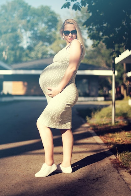 Zdjęcie pięknego kobieta w ciąży relaksujący outside w parku