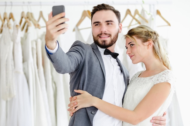Pięknego wzorcowego ślubu pary mienia smartphone online wideo wezwanie patrzeje ekran
