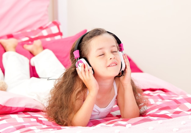 Pięknej Małej Dziewczynki Słuchający Muzyczny Lying On The Beach Na Jej łóżku