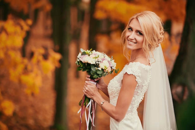 Pięknej narzeczonej pachnący bukiet ślubny w parku jesień z bliska w dniu ślubu