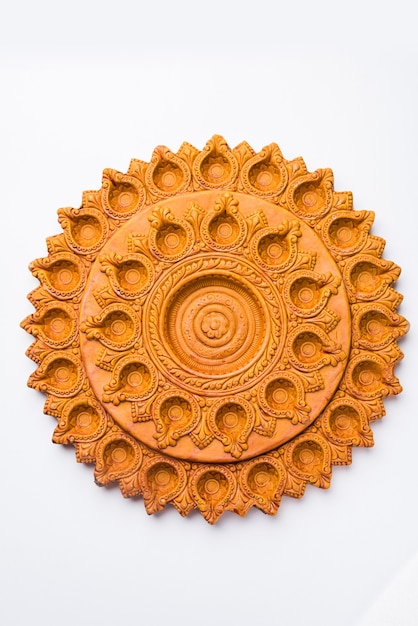Pięknie rzeźbiony projektant Diwali Diya Plate wykonany z terakoty, izolowane i selektywne skupienie