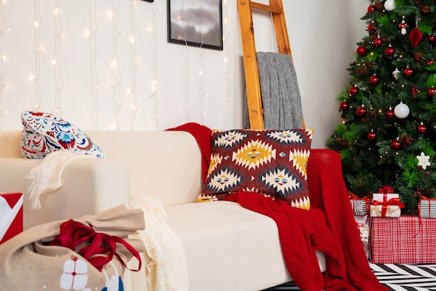 Pięknie urządzony pokój świąteczny z jodłą i białą sofą