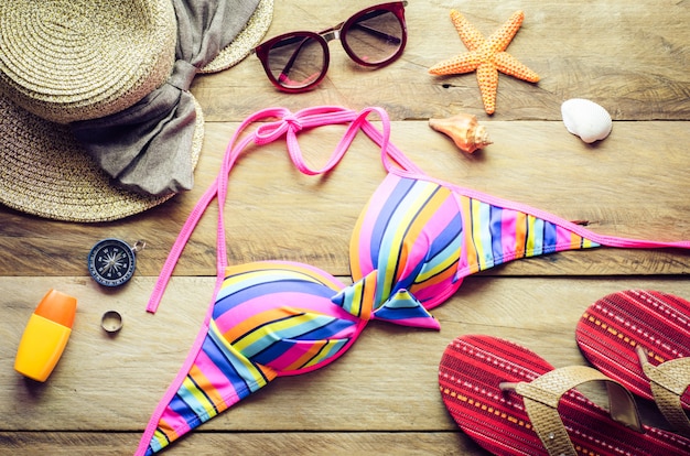 Piękno kolorowy bikini i akcesoria na drewnianej podłoga dla wycieczki na lecie