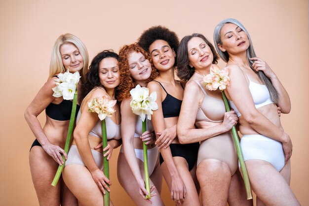 Piękno Obrazu Grupy Kobiet W Różnym Wieku, Skóry I Ciała Pozowanie W Studio Dla Pozytywnej Sesji Zdjęciowej Ciała. Mieszane Modelki W Bieliźnie Na Kolorowym Tle