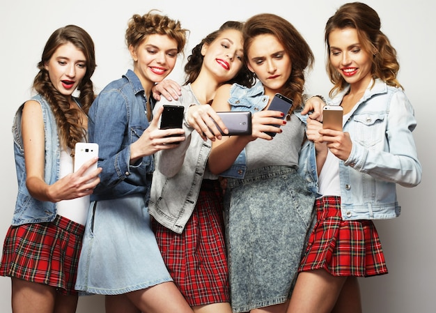 Piękno, przyjaźń, młodość i technologia. Studio portret pięciu wspaniałych młodych kobiet przy selfie.