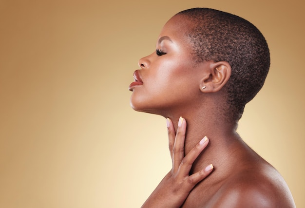Piękno twarzy i makijaż czarnej kobiety w studio do samopielęgnacji blasku skóry lub kosmetyków Profil afrykańskiej modelki estetycznej z dermatologią połysku twarzy i makietą na beżowym tle