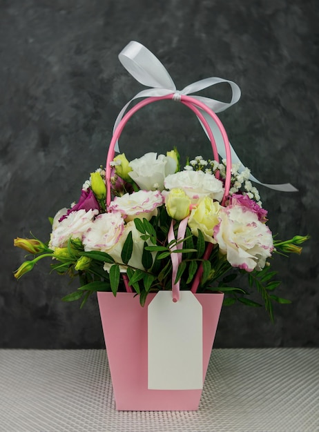 Piękny biały bukiet kwiatów Eustoma Gypsophila w różowym pastelowym koszyku ciemnym tle Kwiatowy prezent kwitnąca tapeta