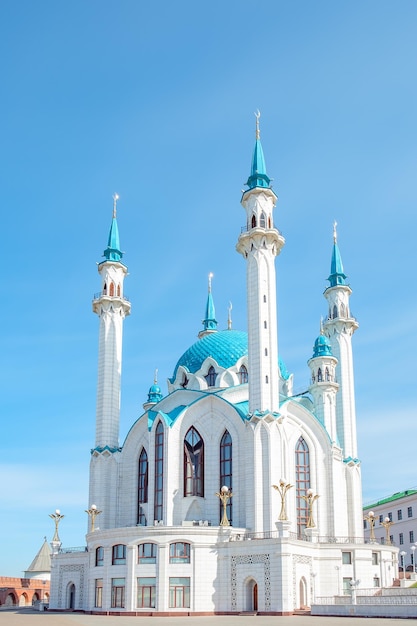 Piękny biały meczet z niebieskim dachem na tle błękitnego nieba w słoneczny letni dzień.