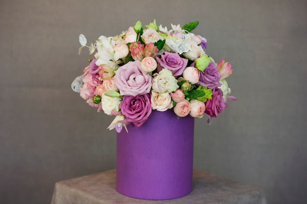 Piękny bukiet kwiaty w purpurach boksuje na szarym tle