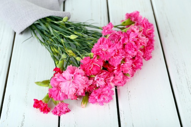 Piękny bukiet różowych goździków na drewnianym stole z bliska