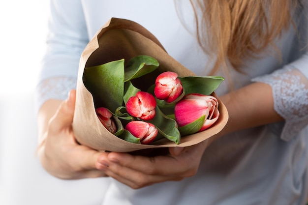 Piękny Bukiet Różowych Tulipanów W Papierze Kraft W Rękach Kobiet