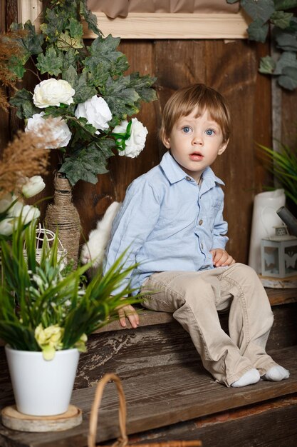 Zdjęcie piękny chłopczyk bawiący się zajączkiem wielkanocnym w zielonej trawie