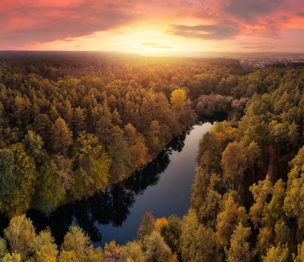 Piękny dramatyczny krajobraz jeziora w lesie jesienią na niebie słońca