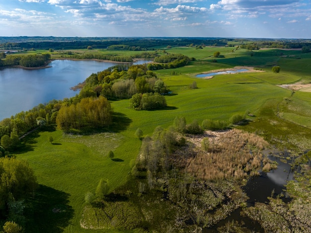 Zdjęcie piękny drone krajobraz przyrody pól łąki las i jezioro słoneczny dzień w polsce mazury