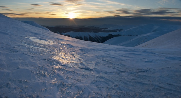 Piękny górski zachód słońca krajobraz z drogą słońca na pokrytym lodem zboczu góry