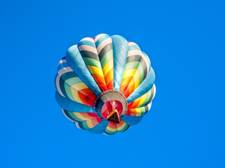 Piękny kolorowy balon na ogrzane powietrze latający na błękitnym niebie