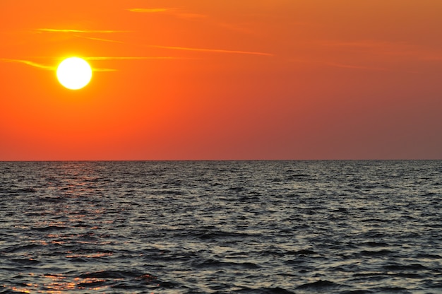 Piękny kolorowy zachód słońca nad falistymi wodami Morza Czarnego na Krymie w letni dzień.